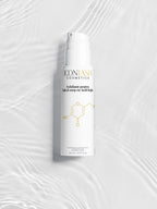 Flaconul exfoliantului IconLash cu acid kojic, pe un fundal alb cu reflexii de apă